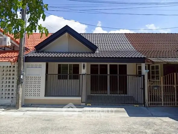 Charming single-story house with modern facade and gated entrance in a serene neighborhood.