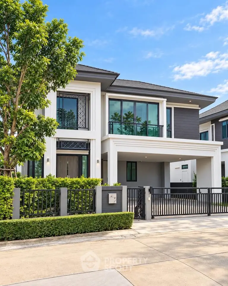 Modern two-story house with large windows and gated driveway in a suburban neighborhood.