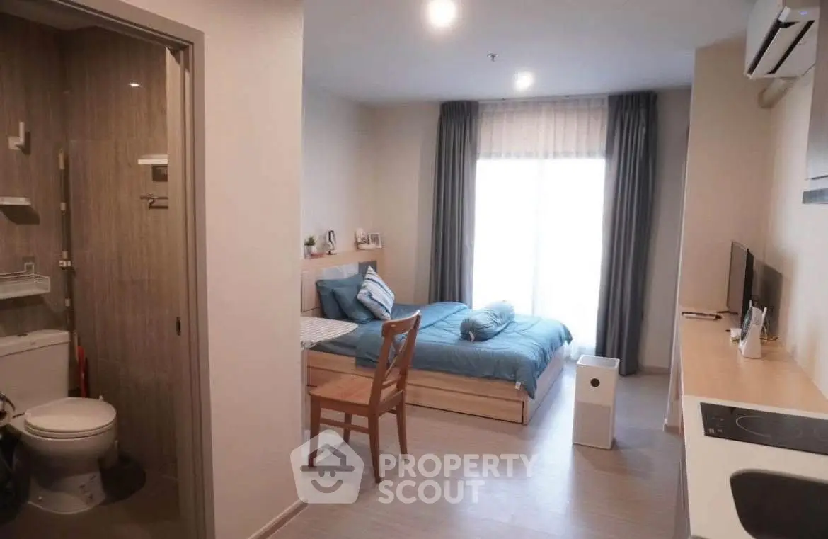 Modern studio apartment with cozy bedroom and compact kitchen