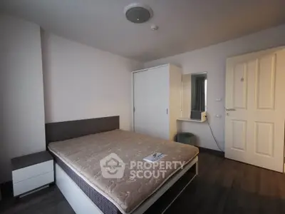 Modern bedroom with minimalist design, featuring a comfortable bed and sleek wardrobe.