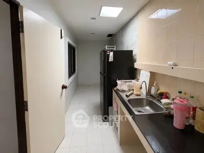 Compact kitchen with sleek countertops and modern appliances in a cozy apartment setting.