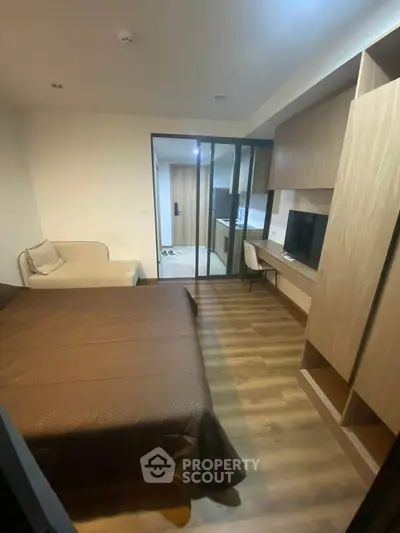 Modern bedroom with wooden flooring and built-in storage in a cozy apartment