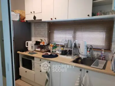 Cozy kitchen with modern appliances and ample storage space, perfect for culinary enthusiasts.