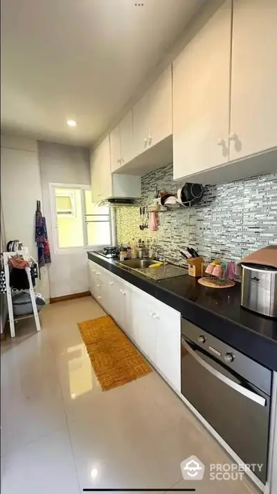 Modern kitchen with sleek cabinetry and gas stove in a bright, spacious layout.