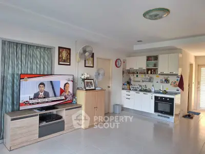 Spacious living room with modern kitchen and entertainment setup, perfect for family gatherings.
