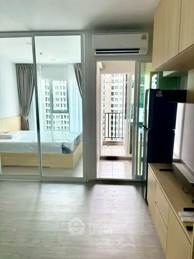 Modern apartment interior with bedroom and balcony view, featuring sleek design and natural light.