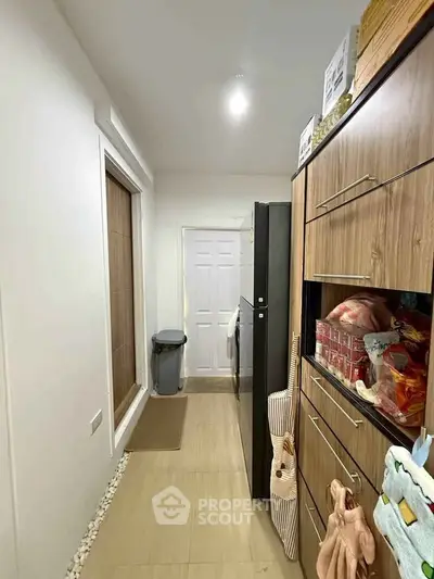 Compact kitchen with modern wooden cabinets and sleek appliances