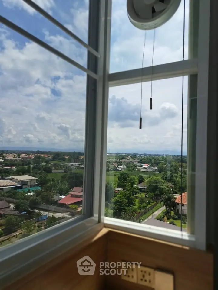 Stunning panoramic view from a modern window overlooking lush greenery and suburban homes.