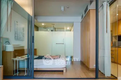 Modern bedroom with glass partition and wooden flooring in stylish apartment