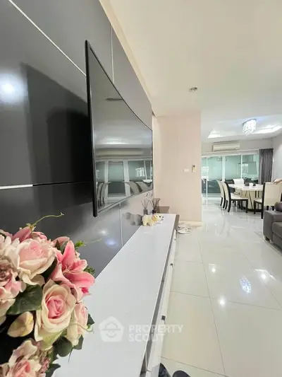 Modern living room with sleek TV setup and elegant dining area