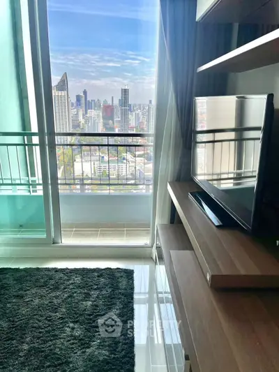 Modern living room with city view and balcony access in high-rise apartment.
