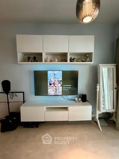 Modern living room with sleek white entertainment unit and wall-mounted TV, showcasing stylish decor.