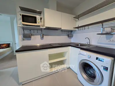 Modern kitchen with sleek appliances and washing machine in a compact layout