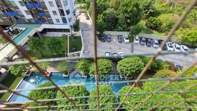 Stunning aerial view of modern apartment complex with lush greenery and inviting swimming pool.
