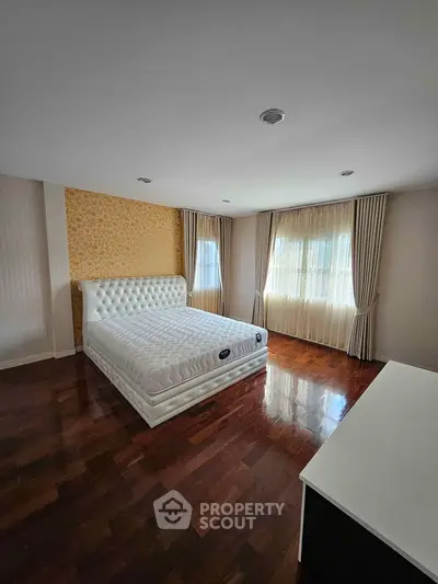 Spacious bedroom with elegant decor and large windows for natural light
