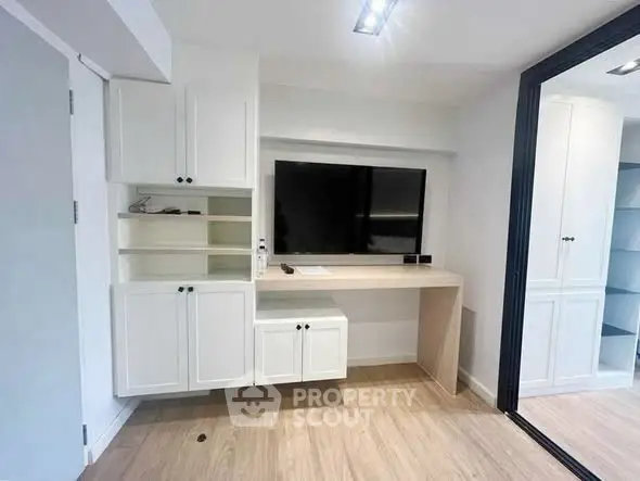Modern study room with built-in cabinets and large TV, perfect for productivity and relaxation.