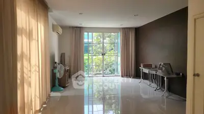 Spacious living room with large windows and natural light, perfect for modern living.