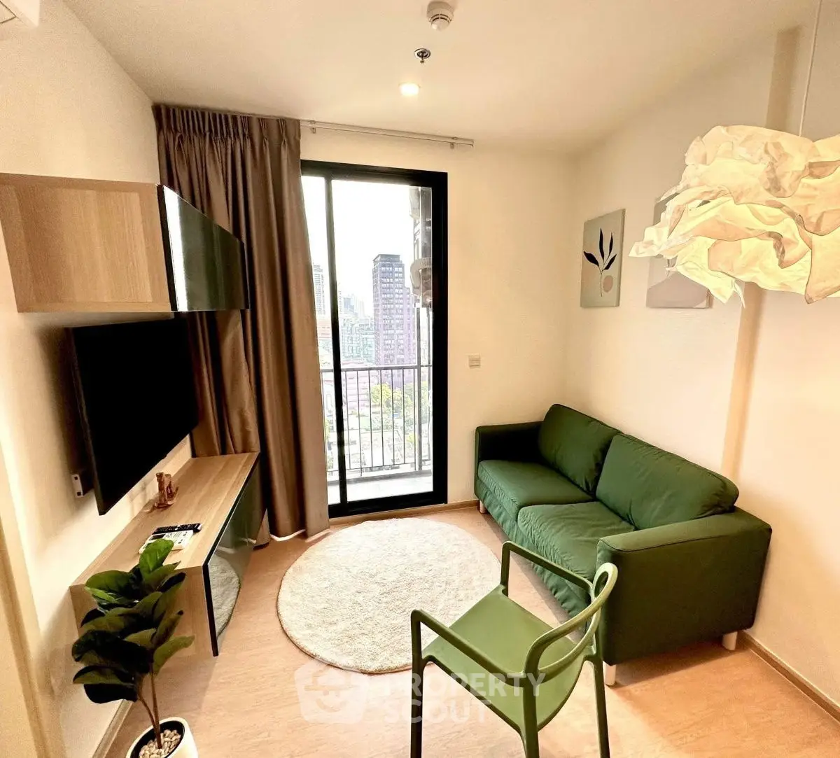 Modern living room with green sofa, balcony view, and stylish decor