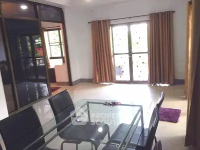 Spacious dining area with glass table and large windows in modern home