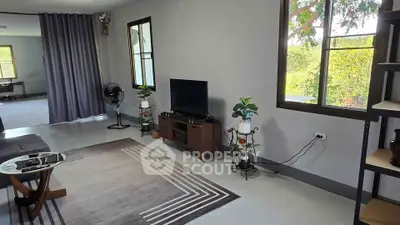 Spacious living room with modern decor and large windows offering natural light and garden views.