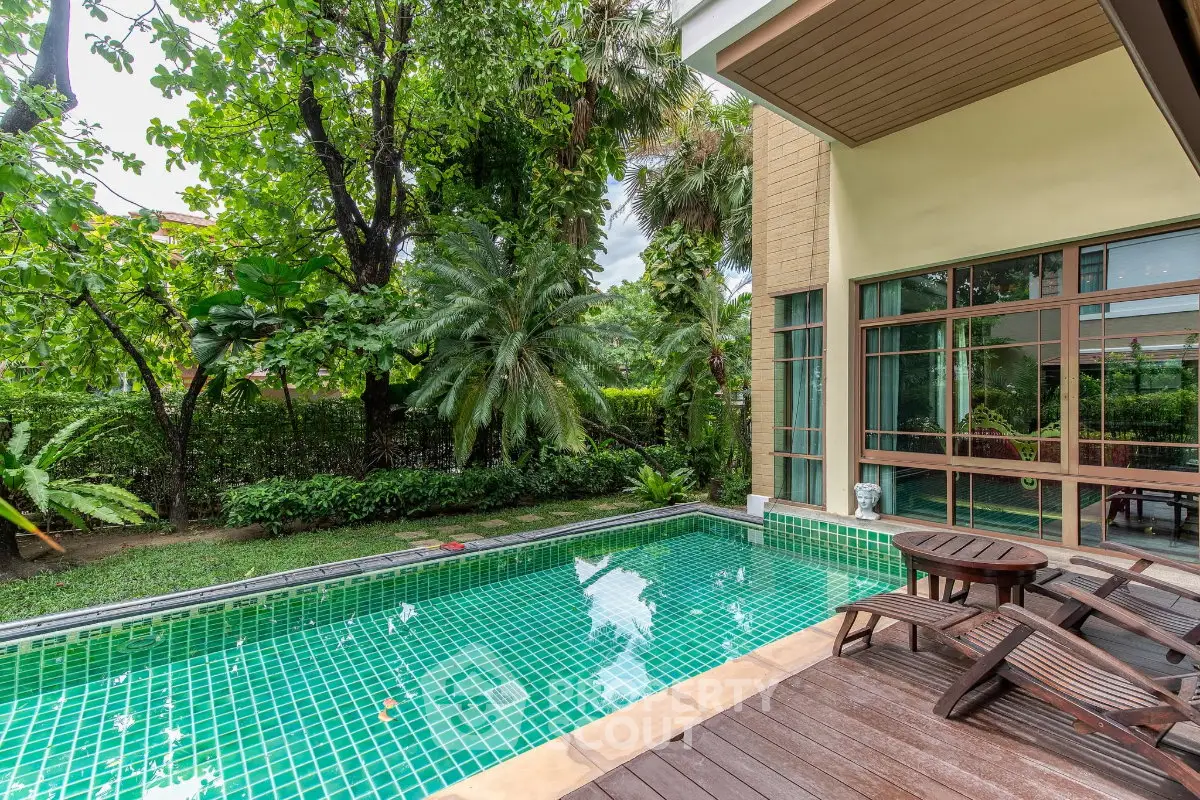 Luxurious private pool area with lush greenery and stylish patio furniture, perfect for relaxation and entertainment.