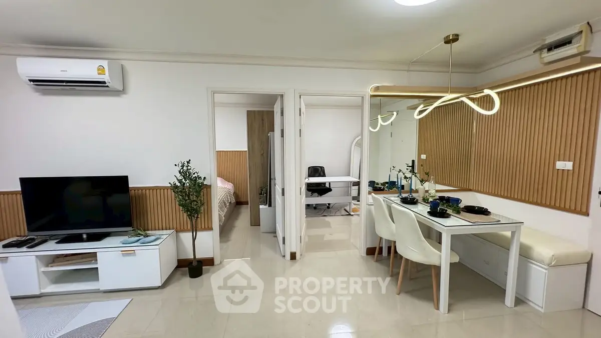 Modern apartment interior with open living and dining area, featuring stylish decor and natural light.