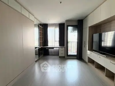 Spacious modern living room with built-in storage and large window view.