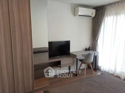 Modern bedroom with sleek furniture, TV, and air conditioning, perfect for comfort and style.