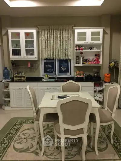Charming kitchen with elegant dining set and decorative cabinets in cozy home setting.