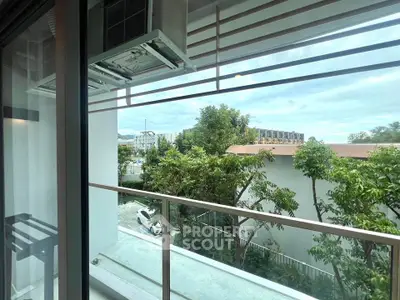 Modern balcony with lush greenery and city view, perfect for relaxation and enjoying the outdoors.