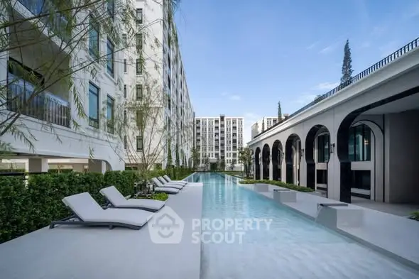 Luxurious modern apartment complex with stunning pool and elegant architecture.