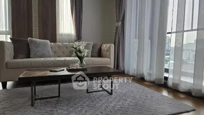 Elegant living room with plush sofa, stylish coffee table, and floor-to-ceiling windows for natural light.