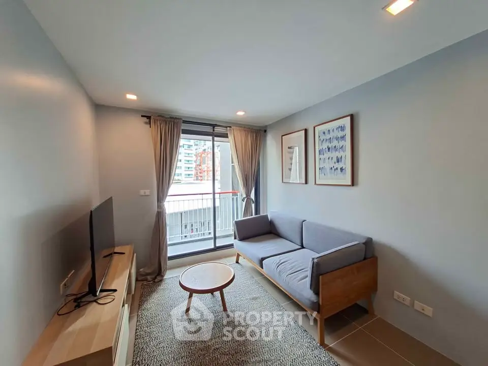 Modern living room with balcony view, featuring sleek furniture and natural light.