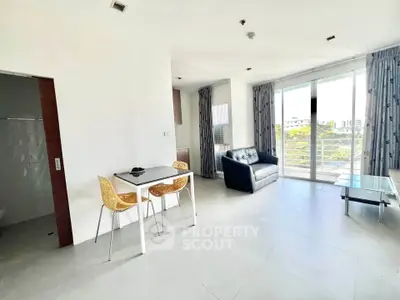 Modern living room with balcony view, sleek furniture, and abundant natural light.