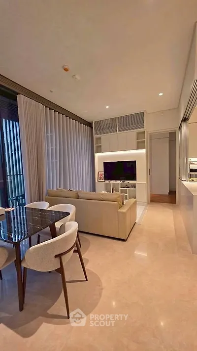 Modern living room with elegant dining area and cozy seating, featuring floor-to-ceiling windows and stylish decor.