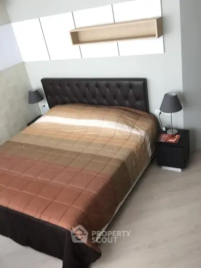 Modern bedroom with stylish headboard and elegant bedside lamps