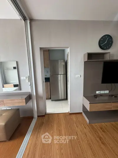 Modern apartment interior with sleek kitchen and stylish living area, featuring wood flooring and contemporary decor.