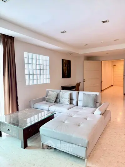 Spacious modern living room with elegant sectional sofa and natural light.