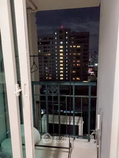 Charming balcony view of city skyline at night from a cozy apartment.