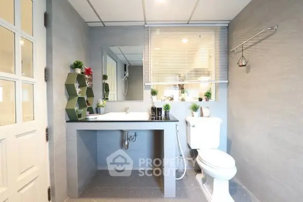 Modern bathroom with sleek design, featuring a large mirror, stylish sink, and contemporary decor.