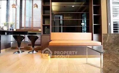 Modern living room with stylish furniture and wooden flooring, featuring a cozy seating area and elegant decor.