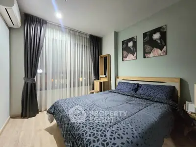 Modern bedroom with stylish decor and large window in a cozy apartment.