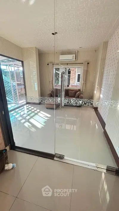 Spacious living room with glass doors and air conditioning, perfect for modern living.