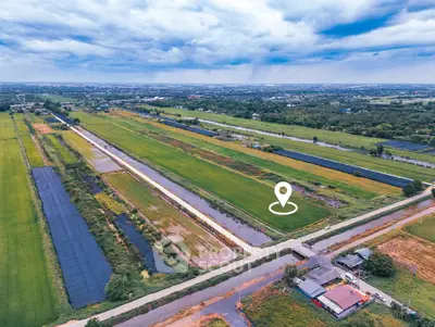 Expansive aerial view of lush green fields with a potential real estate development site marked.