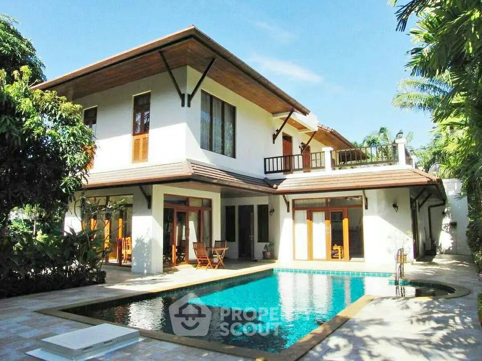 Luxurious two-story villa with private pool and lush garden, perfect for tropical living.