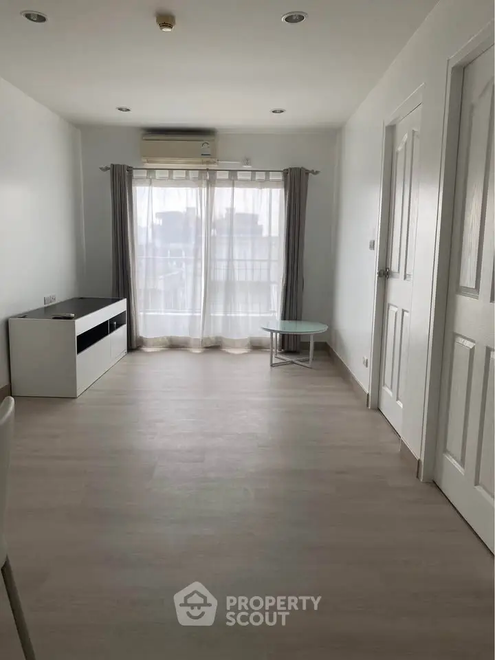 Spacious minimalist living room with large window and modern decor