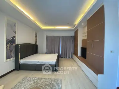 Spacious modern bedroom with elegant lighting and stylish built-in storage