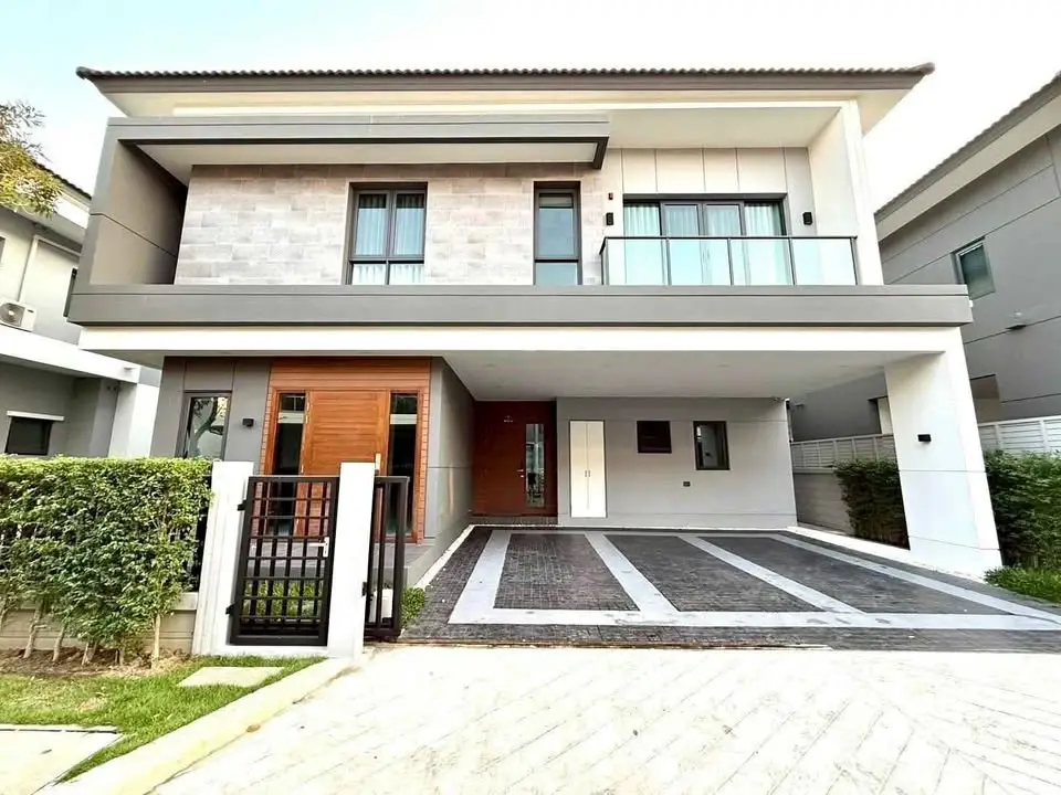 Modern two-story house with spacious driveway and stylish facade in a serene neighborhood.