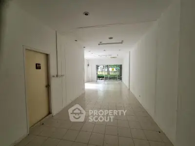 Spacious empty room with tiled flooring and large windows for natural light
