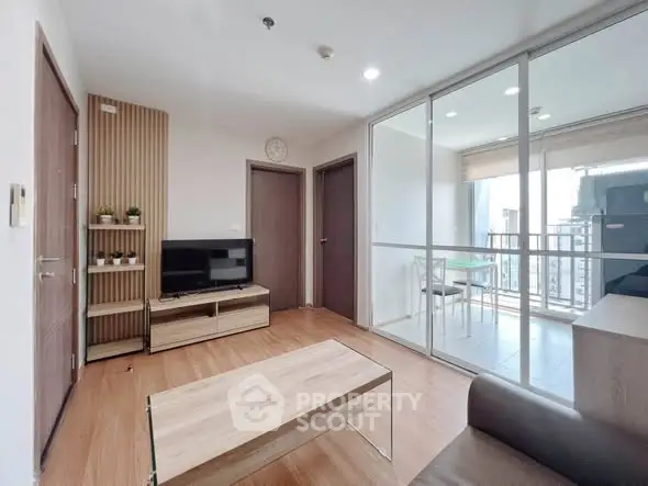 Modern living room with glass partition and balcony view in a stylish apartment.